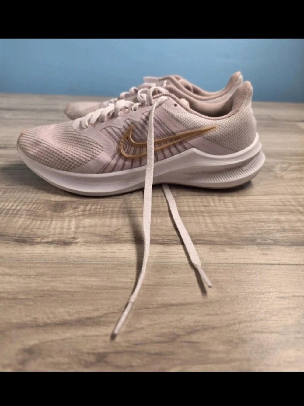 Nike Women's Pale Pink Running Sneakers with Gold Swoosh Accent